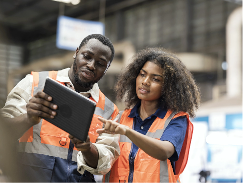Warehouse workers looking at tablet.